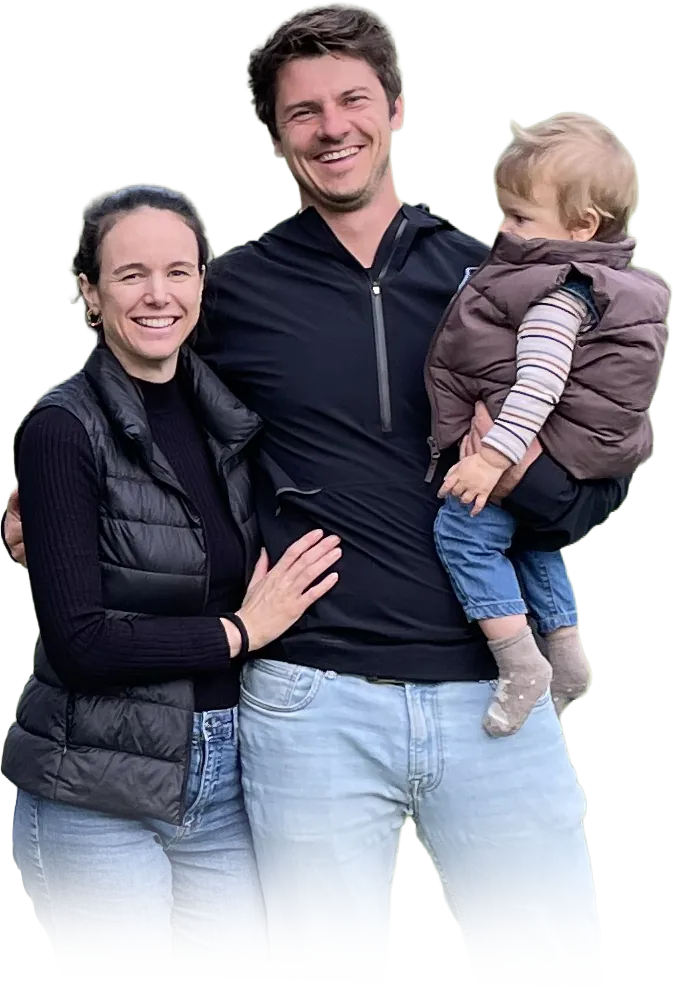Die Familie vom Hof Gritzenmoos auf der Wiese vor den Obstbäumen, der Vater mit dem Kleinkind auf dem Arm